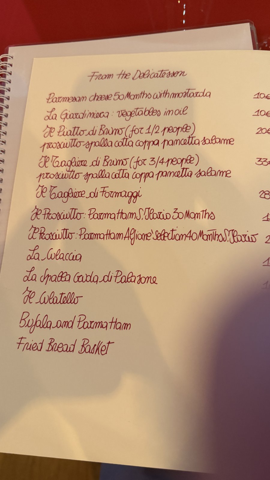 A handwritten delicatessen menu — Parma ham aged 30 and 40 months, cheese boards — photographed on the trip, AI Super Simplified